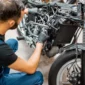 Monteur repareert motor van motorfiets.